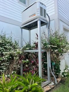 Generac generator on an elevated aluminum stand beside a home